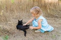 Young kind girl and black cat. Royalty Free Stock Photo