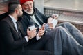 Young kind-hearted businessman and senior beggar look at phone Royalty Free Stock Photo