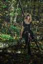 A young kind witch in a black dress with a black mask in a mystical forest in various poses. Art processing