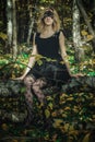 A young kind witch in a black dress with a black mask in a mystical forest in various poses. Art processing