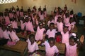 Young kindergarten Haitian school girls and boys show friendship bracelets in school classroom.