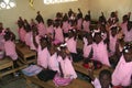 Young kindergarten Haitian school girls and boys show friendship bracelets in school classroom.