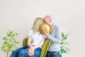 The young kissing couple hiding behind straw hat at home.