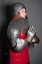 A young knight in medieval armor prays with his hands clasped Royalty Free Stock Photo