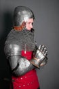 A young knight in medieval armor prays with his hands clasped Royalty Free Stock Photo