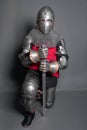 A young knight in medieval armor with a weapon in his hands kneeled Royalty Free Stock Photo