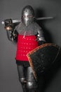 A young knight in medieval armor with a weapon in his hands kneeled Royalty Free Stock Photo