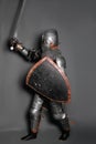 A young knight in medieval armor with a weapon in his hands kneeled Royalty Free Stock Photo