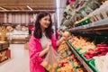 Young Korean woman shopping without plastic bags in grocery store. Vegan zero waste girl choosing fresh fruits and vegetables in Royalty Free Stock Photo