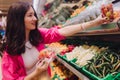 Young Korean woman shopping without plastic bags in grocery store. Vegan zero waste girl choosing fresh fruits and vegetables in Royalty Free Stock Photo
