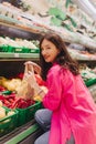 Young Korean woman shopping without plastic bags in grocery store. Vegan zero waste girl choosing fresh fruits and vegetables in Royalty Free Stock Photo