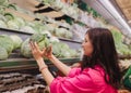 Young Korean woman shopping without plastic bags in grocery store. Vegan zero waste girl choosing fresh fruits and vegetables in Royalty Free Stock Photo