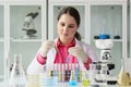 Young laboratory technician examines test tubes with liquids