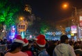 Young ladies with red santa claus hats enjoying themselves at illuminated and decorated park street with lights with year end Royalty Free Stock Photo