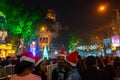 Young ladies with red santa claus hats enjoying themselves at illuminated and decorated park street with lights with year end Royalty Free Stock Photo