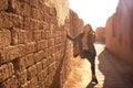 A young lady in an ancient street in Nisa, Turkmenistan at sunset