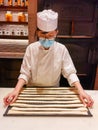 14-11-2020: young lady baker explains to customers how to make Italian grissini bread sticks, a long thin crisp bread baked from