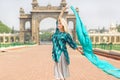 Young lady in blue shirt catching wind past the Historical gates of the royal Palace of Mysore in Karnataka, India.