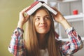 Young lady with book over head