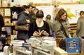 Young lady with book reading new stories in crowd