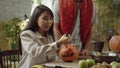 A young lady carves a pumpkin for Halloween