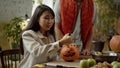 A young lady carves a pumpkin for Halloween