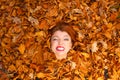 Young lady covered by leaves.