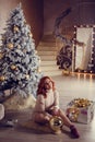 young lady with curlu hair gifts by the fireplace near the Christmas tree. New year concept Royalty Free Stock Photo