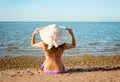 Young lady with curly hair and hat sitting on sand Royalty Free Stock Photo