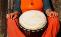 Young lady drummer with her djembe drum on rustic wooden door background Royalty Free Stock Photo