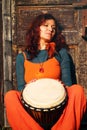 Young lady drummer with her djembe drum on rustic wooden door background Royalty Free Stock Photo