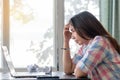 Young lady feeling tired and stressed. woman working with laptop computer and paperwork.