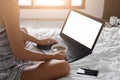 Young lady freelancer sitting on the bed in hotel room Royalty Free Stock Photo