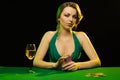 A young lady in a green dress is playing solitaire made from scrying cards Royalty Free Stock Photo