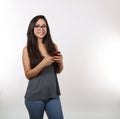 Young Lady in Grey Shirt and Glasses Holds Phone Royalty Free Stock Photo