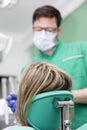 Young lady having her teeth examined by a dentist