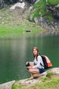 Young lady hiker with backpack sitting on mountain Royalty Free Stock Photo