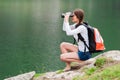 Young lady hiker with backpack sitting on mountain Royalty Free Stock Photo