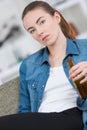 young lady holding bottle beer sad expression Royalty Free Stock Photo