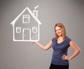 Young lady holding a huge drawn house