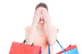 Young lady holding shopping bags making blind gesture