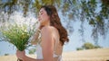 Young lady inhaling daisies fragrance summer countryside closeup. Woman walking Royalty Free Stock Photo