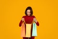 Young lady looking inside shopping bag and smiling Royalty Free Stock Photo
