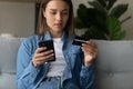 Young lady making purchase at internet shop using cell