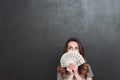 Young lady over grey wall holding money in hands Royalty Free Stock Photo