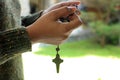 Young lady prayer hand holding rosary beads with Jesus Christ holy cross crucifix. Praying The Rosary everyday concept.