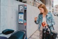 young lady paying for her parking ticket using credit card at pay station terminal on city street Royalty Free Stock Photo