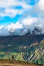 A young lady photographer with a stunning scenery of rocky mountain covered with snow after the raining day. Cloudy and foggy. Royalty Free Stock Photo