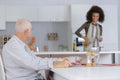 Young lady preparaing meal for elderly man