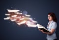 Young lady reading a book with flying sheets coming out of the b Royalty Free Stock Photo